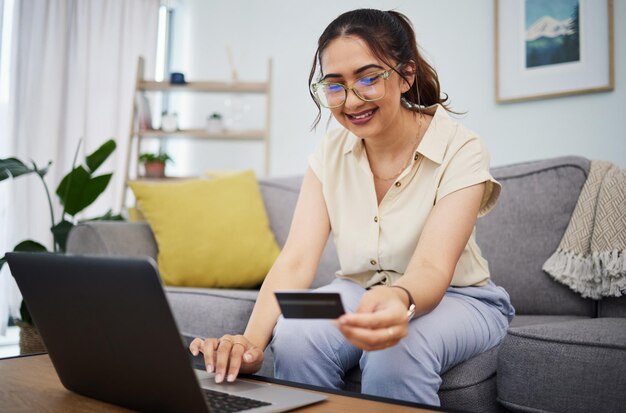 Tarjeta de crédito de mujer y comercio electrónico en una computadora portátil en casa para pago digital, contraseña de fintech y compras en línea Computadora de cliente femenina feliz y código bancario para facturas financieras, presupuesto y cuenta