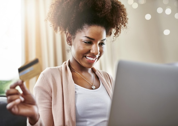 Tarjeta de crédito portátil y mujer negra en casa para compras en línea compra e pago en Internet comercio electrónico fintech y persona feliz en la computadora para ofertas descuento y venta sitio web para banca digital