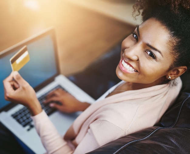 Tarjeta de crédito portátil y retrato de mujer negra en el sofá para compras en línea compra o pago en Internet Ecommerce fintech y persona feliz en la computadora para venta en el sitio web o banca digital en el hogar