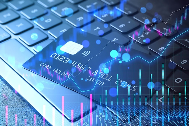 Tarjeta de crédito sobre teclado con gráficos financieros de la bolsa de valores concepto creativo de doble exposición en un fondo oscuro