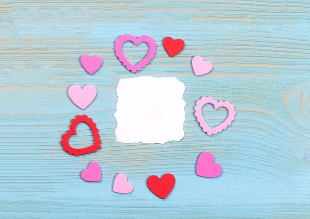 Foto tarjeta del día de san valentín de corazones de papel rojo sobre fondo blanco