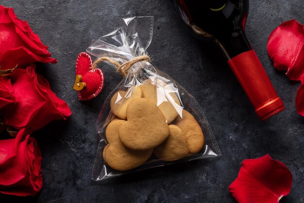 Tarjeta del día de san valentín con galletas de botella de vino y flores de rosa