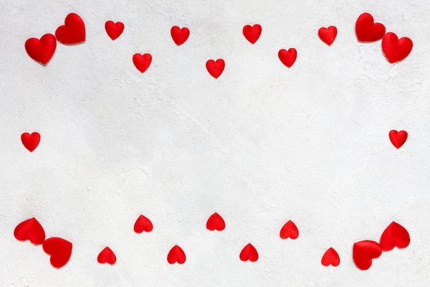 Tarjeta para el día de San Valentín con un marco de corazones textiles rojos sobre fondo blanco.