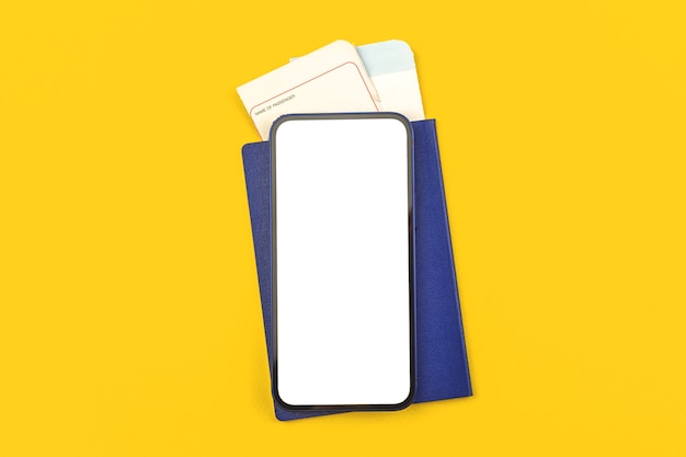 Tarjeta de embarque con pasaporte y maqueta de teléfono inteligente, pantalla blanca en blanco con espacio de copia, fondo de escritorio de oficina amarillo, prepararse para el concepto de viaje