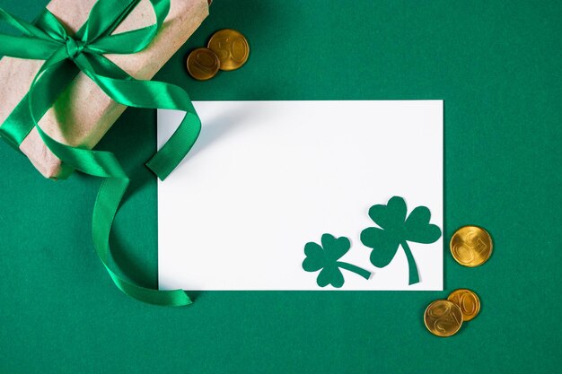 Tarjeta de felicitación para el Día de San Patricio sobre fondo verde Monedas de oro trébol y regalo