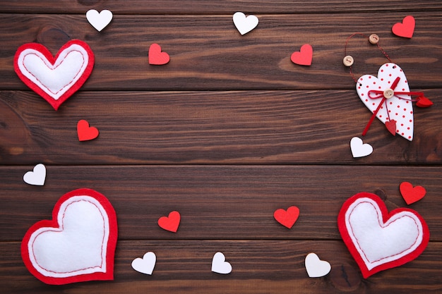 Tarjeta de felicitación del día de San Valentín. Corazones hechos a mano sobre fondo marrón.