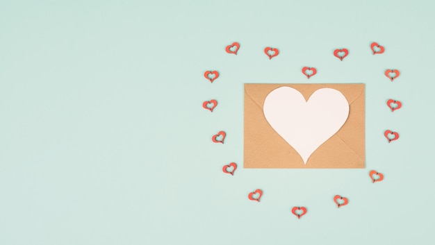 Tarjeta de felicitación del día de San Valentín, sobre con corazones sobre fondo pastel, símbolo de amor, puesta plana