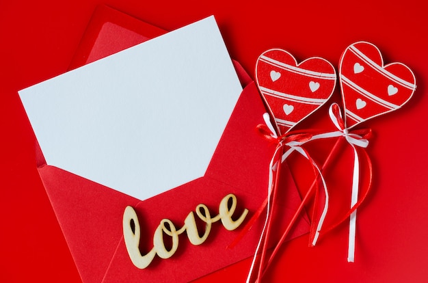 Tarjeta de felicitación para el día de San Valentín. Sobre rojo con papel blanco en blanco. Maqueta de carta de amor.