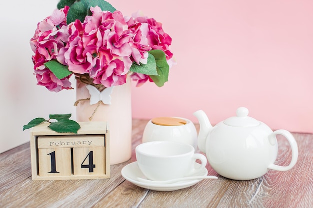 Tarjeta de felicitación feliz día de San Valentín calendario de madera y rosas rosadas en un espacio de copia aislado