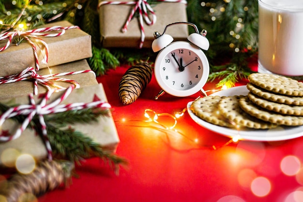 tarjeta de felicitación feliz navidad año nuevo decoraciones regalos reloj ramas de abeto galletas y leche