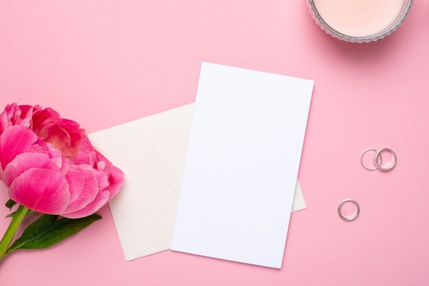 Tarjeta de felicitación con una hermosa flor de peonía y anillos