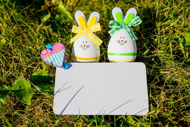 tarjeta de felicitación y huevos de pascua en pasto verde