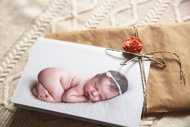 Foto tarjeta de felicitación impresa con bebé recién nacido durmiendo sobre fondo de punto ropa de bebé otoño invierno