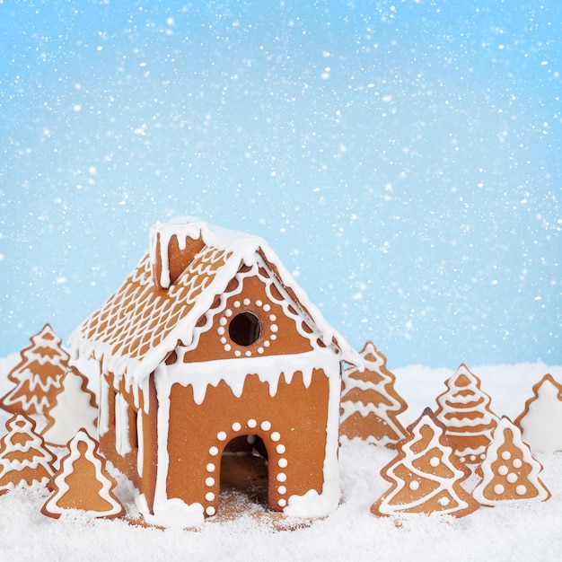 Tarjeta de felicitación de Navidad con casa de pan de jengibre pan de jengibre abetos en la nieve y el espacio de copia