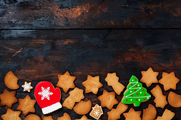 Tarjeta de felicitación de Navidad con pan de jengibre sobre superficie de madera vieja. Vista superior