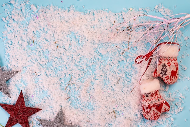 Tarjeta de felicitación de Navidad con ramas de nieve y guantes en azul nieve