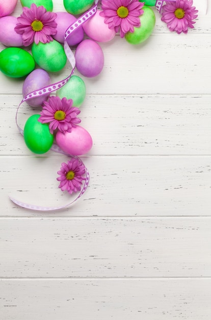 Tarjeta de felicitación de pascua con coloridos huevos de pascua y flores.