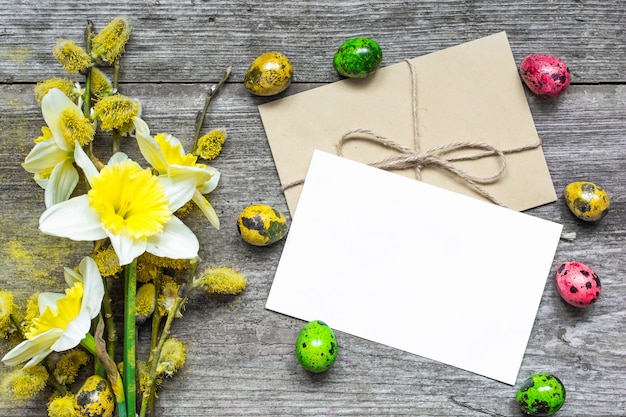 Tarjeta de felicitación de Pascua con huevos de pascua y flores de primavera