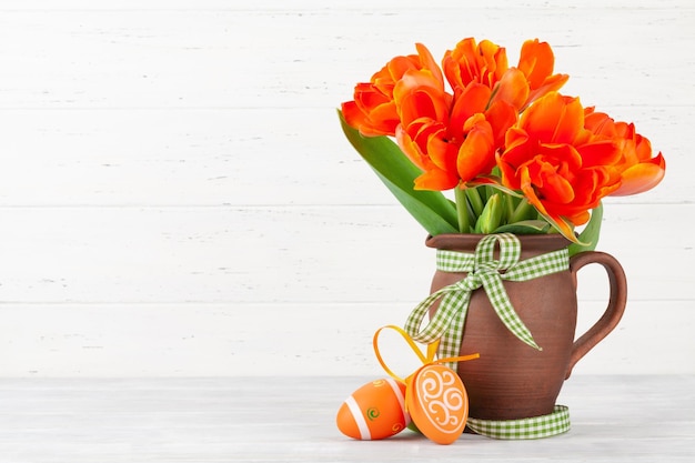 Tarjeta de felicitación de pascua con huevos de pascua y flores de tulipán