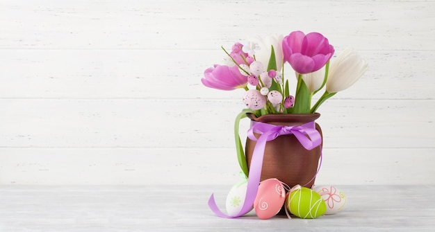 Tarjeta de felicitación de pascua con huevos de pascua y flores de tulipán