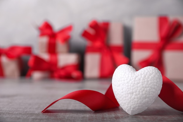 Tarjeta de felicitación de San Valentín con corazones sobre fondo de madera y regalo. Con espacio para tus saludos de texto