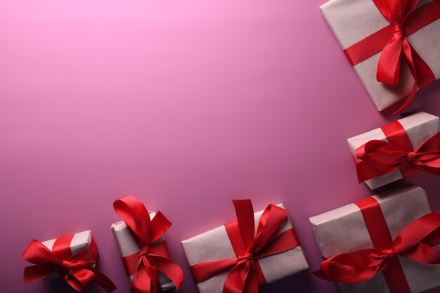 Tarjeta de felicitación de San Valentín fondo símbolos de amor, decoración roja con cajas de regalos sobre fondo rosa. Vista superior con espacio de copia y texto.