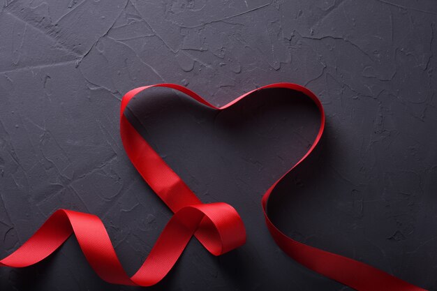 Tarjeta de felicitación de San Valentín fondo símbolos de amor, decoración roja con corazón sobre fondo de piedra. Vista superior con espacio de copia y texto.
