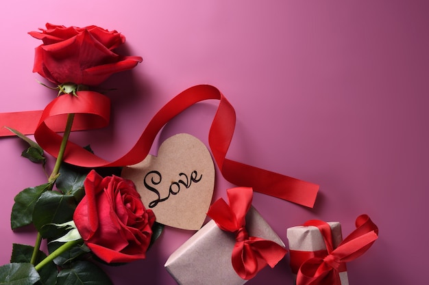 Tarjeta de felicitación de San Valentín fondo símbolos de amor, decoración roja con gafas corazón rosas regalos. Vista superior con espacio de copia y texto.