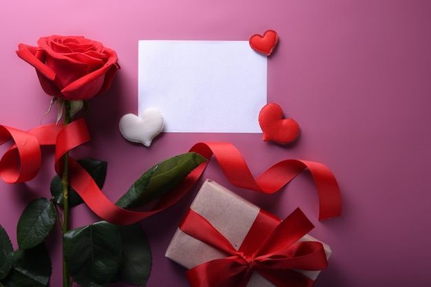 Tarjeta de felicitación de San Valentín fondo símbolos de amor, decoración roja con gafas corazón rosas regalos. Vista superior con espacio de copia y texto.