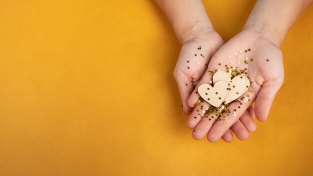 Tarjeta de felicitación símbolo de amor día de san valentín corazón romántico en manos de mujer sobre fondo amarillo con cop ...