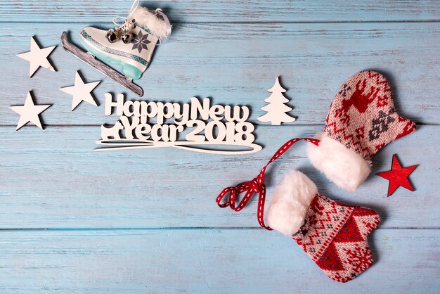 Tarjeta feliz año nuevo 2018 con patines de hielo y mitones
