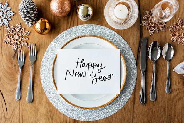 Tarjeta de feliz año nuevo y ajustes de mesa festiva