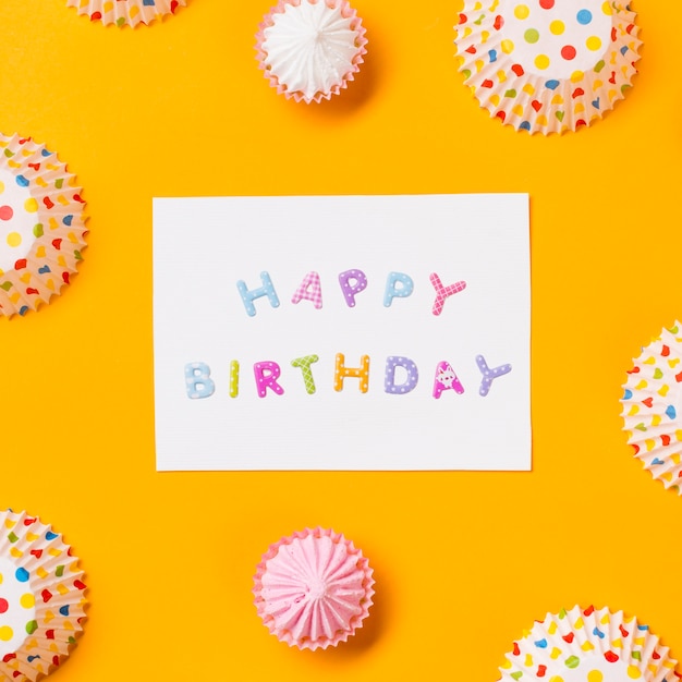 Tarjeta de feliz cumpleaños decorada con formas de pastel de papel de aalaw y lunares sobre fondo amarillo