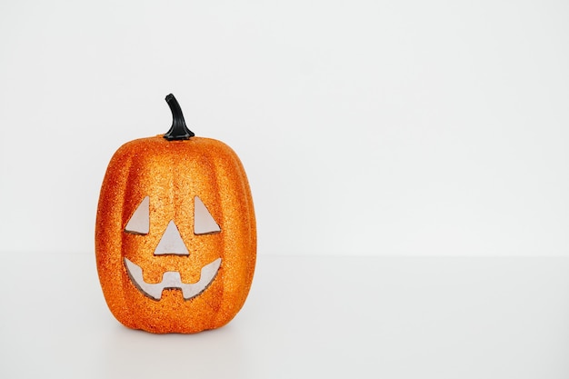 Tarjeta de Halloween con calabaza de cara de miedo sobre un fondo blanco, espacio de copia