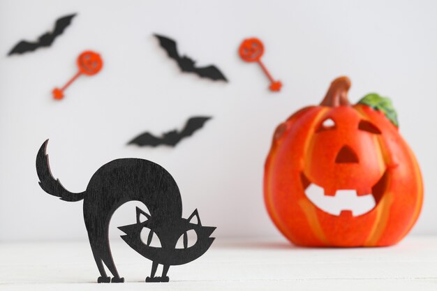 Tarjeta de Halloween con gato negro, Jack-o-latern y murciélagos. Enfoque selectivo