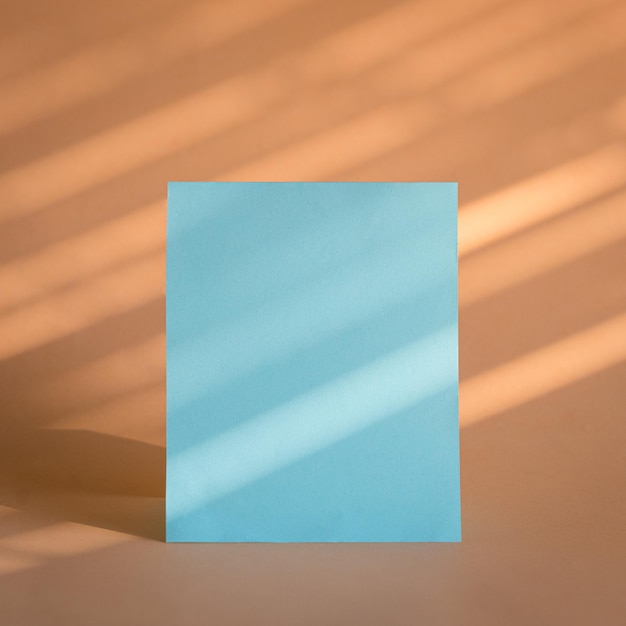 Tarjeta de hoja de papel azul en blanco con fondo beige
