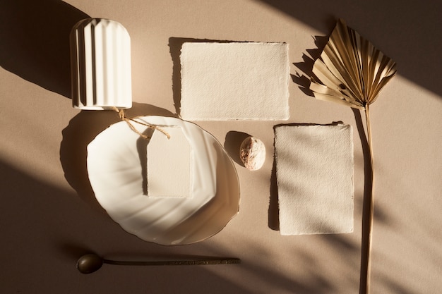 Foto tarjeta de invitación de saludo de boda blanco en blanco con etiqueta, hojas secas de palmeras tropicales, placa de florero, en mesa de madera con textura plantilla moderna elegante. vista superior plana