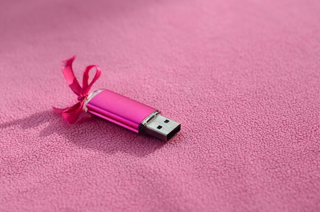 Tarjeta de memoria flash usb rosa brillante con un lazo rosa