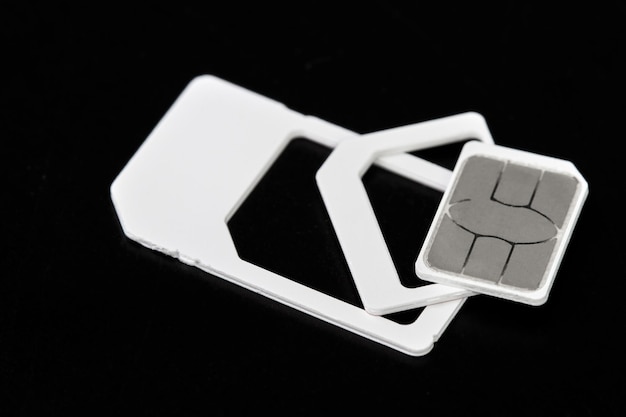 Foto tarjeta nano sim extraída de adaptadores de tarjeta sim sobre fondo oscuro