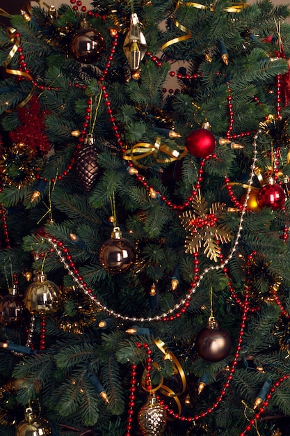 Tarjeta de Navidad y árbol de Navidad de fondo decorado con bolas de perlas rojas y doradas y guirnaldas