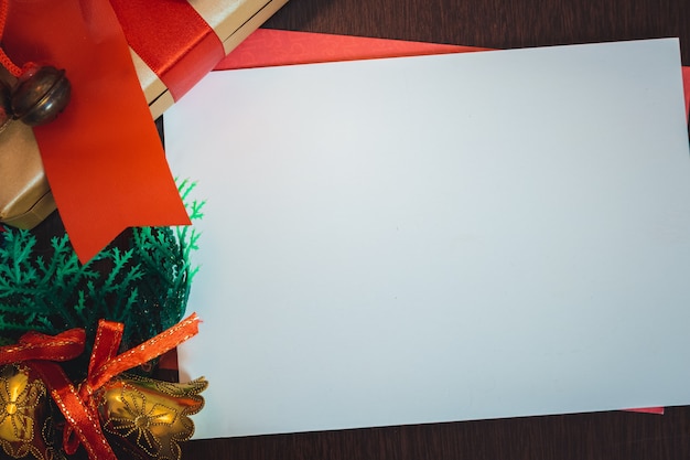 Foto tarjeta de navidad en blanco con fondo borroso con santa claus, regalos y adornos navideños. espacio para texto.