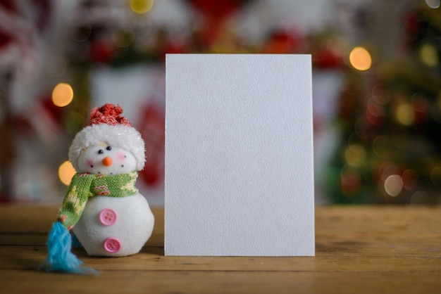 Tarjeta de Navidad en blanco junto al adorno en la mesa de madera Fondo de Navidad Maqueta de tarjeta de Navidad