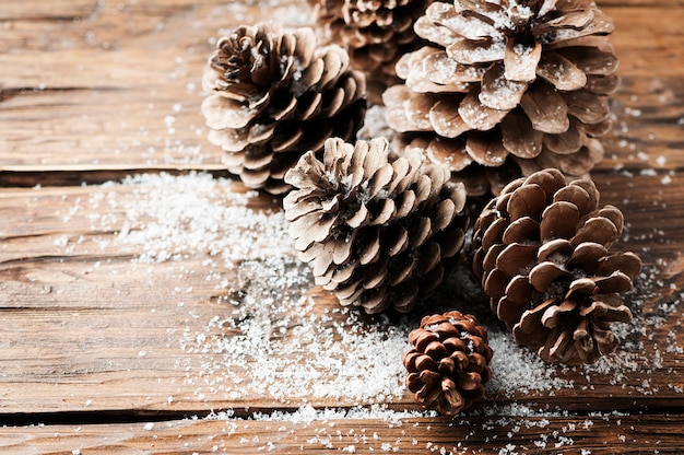 Tarjeta de navidad con conos en la mesa de madera