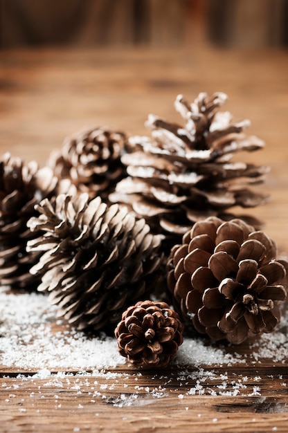 Tarjeta de navidad con conos en la mesa de madera