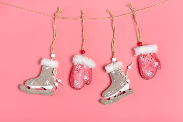 Tarjeta de Navidad, decoración de año nuevo: mitones y patines de madera rojos se cuelgan en una cuerda