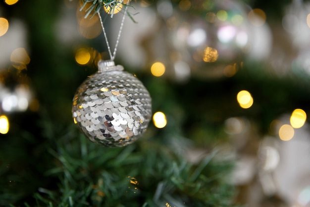 Tarjeta de Navidad decoración navideña bola de lentejuelas con fondo de ramas y guirnaldas