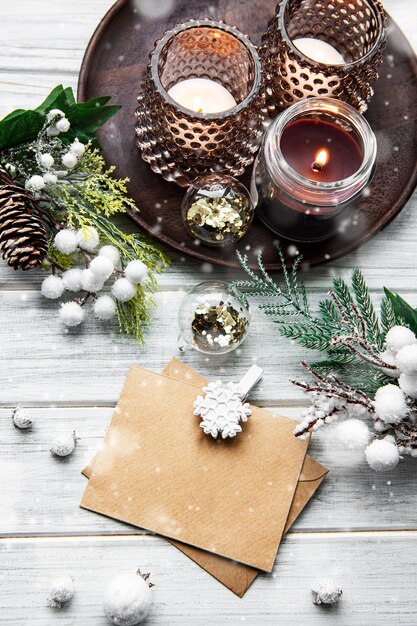 Tarjeta de navidad y feliz año nuevo con velas, pino, abeto sobre fondo blanco de madera, vista superior