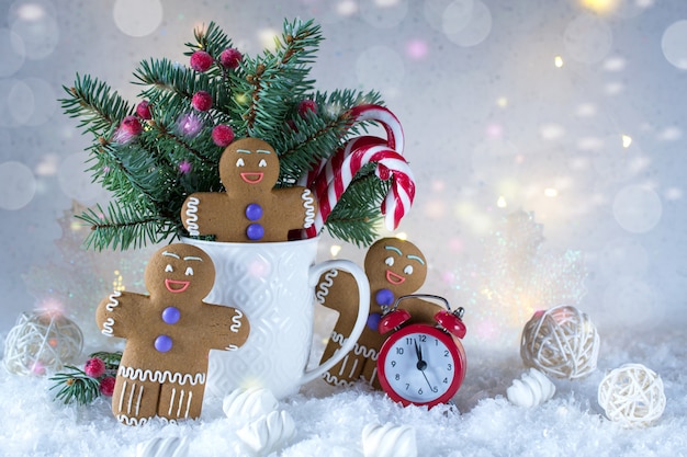 Tarjeta de navidad o año nuevo. Taza con abetos, bastones de caramelo y galletas de jengibre.