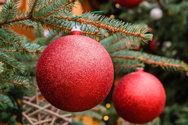 Tarjeta de Navidad. Primer plano de dos bolas rojas de Año Nuevo en una rama del árbol de Navidad natural