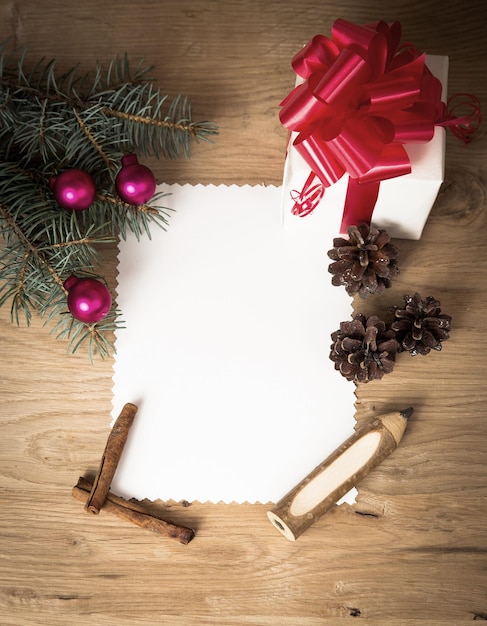 Foto tarjeta de navidad regalo rural vintage en blanco y rama de árbol de navidad sobre fondo de madera